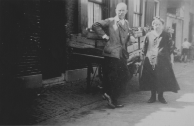 875148 Afbeelding van opa en opoe van Soest, bij een handkar vol groentenkisten, voor hun woning Kroonstraat 16 in Wijk ...